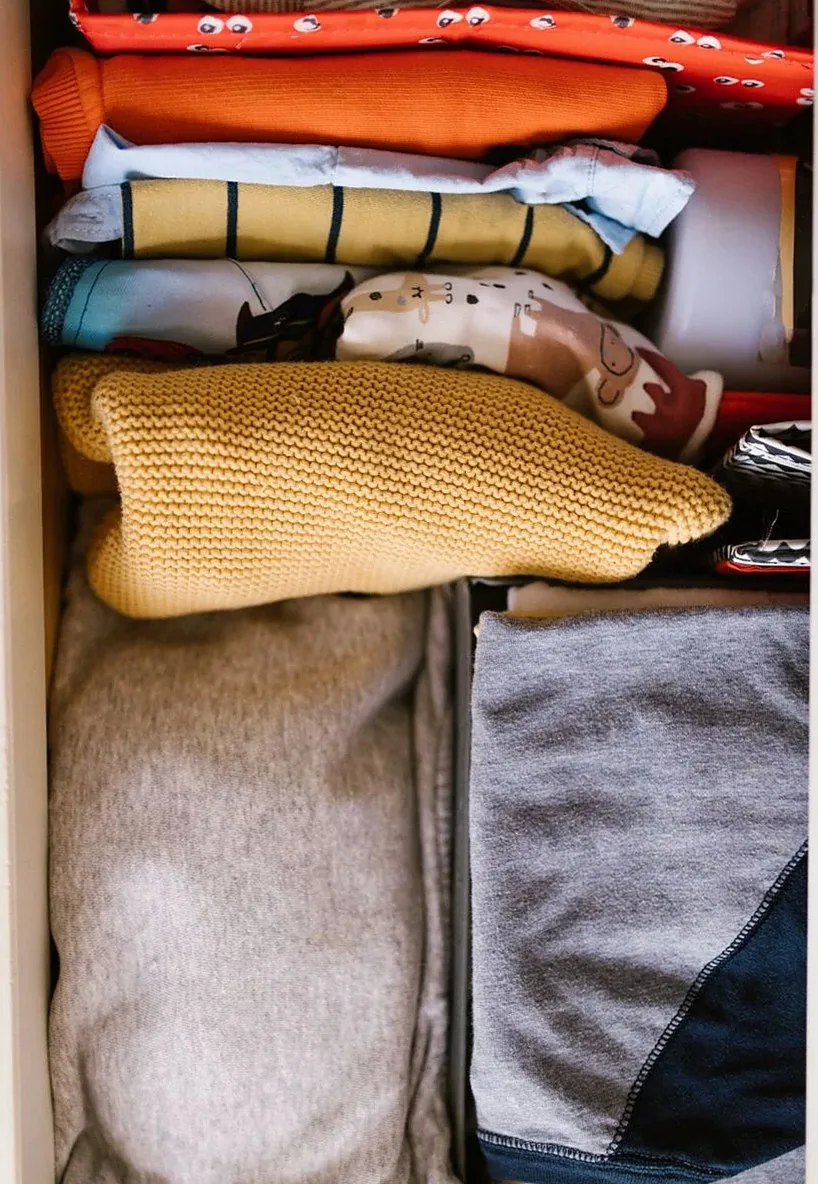 Colorful clothes folded neatly in a drawer, showcasing an organized space from an overhead view.